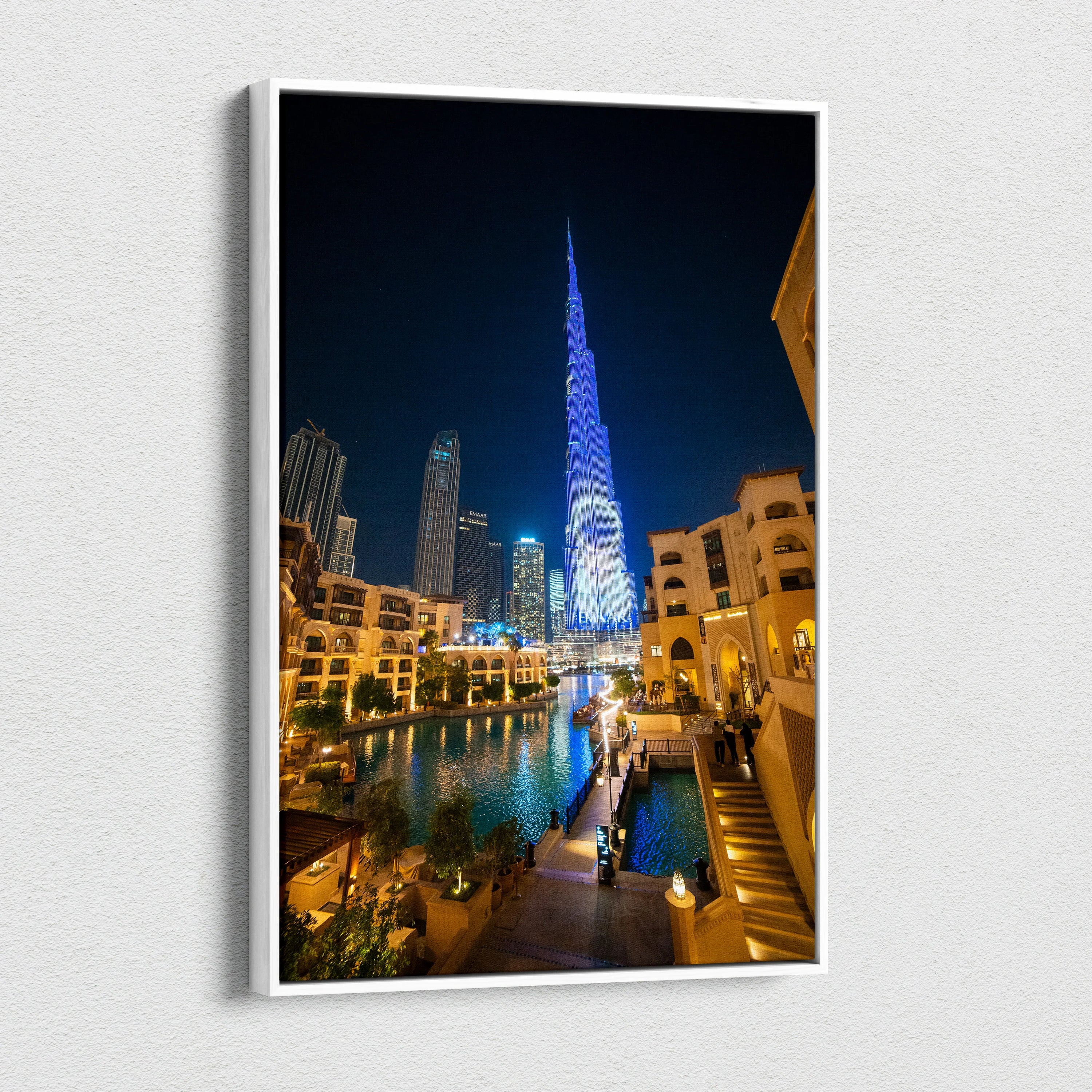Canvas wall art featuring a nighttime cityscape with illuminated modern skyscrapers and a water canal reflecting vibrant.