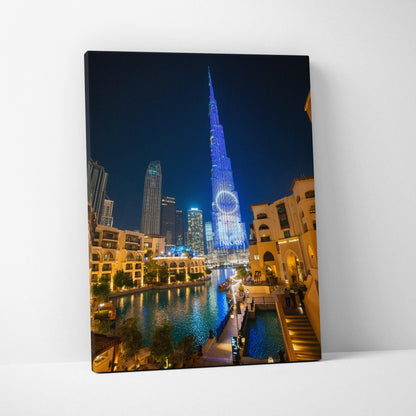 Canvas wall art featuring a nighttime cityscape with illuminated modern skyscrapers and reflections on water.