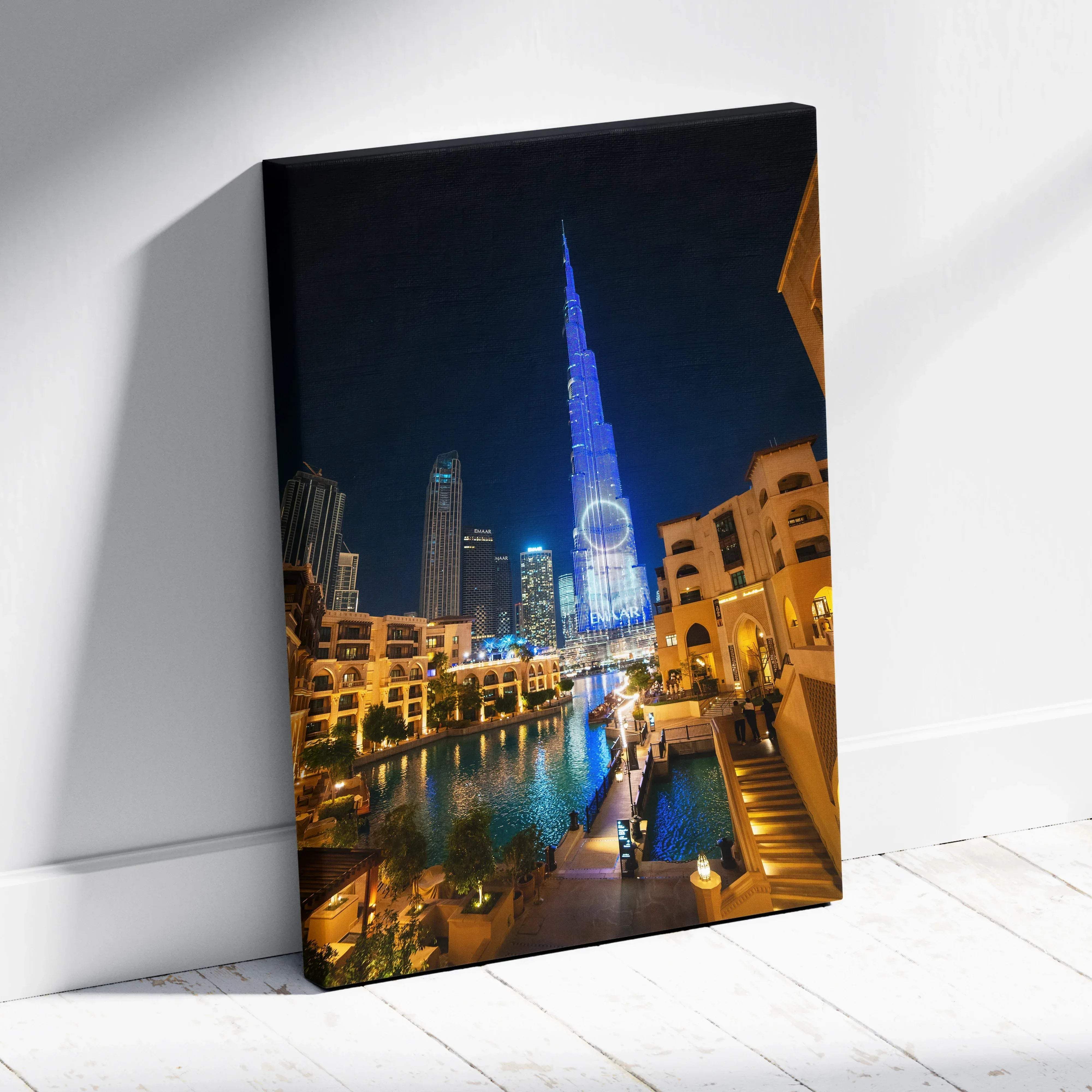 A framed canvas print of burj khalifa illuminated in blue neon with dubai night skyline and water reflections