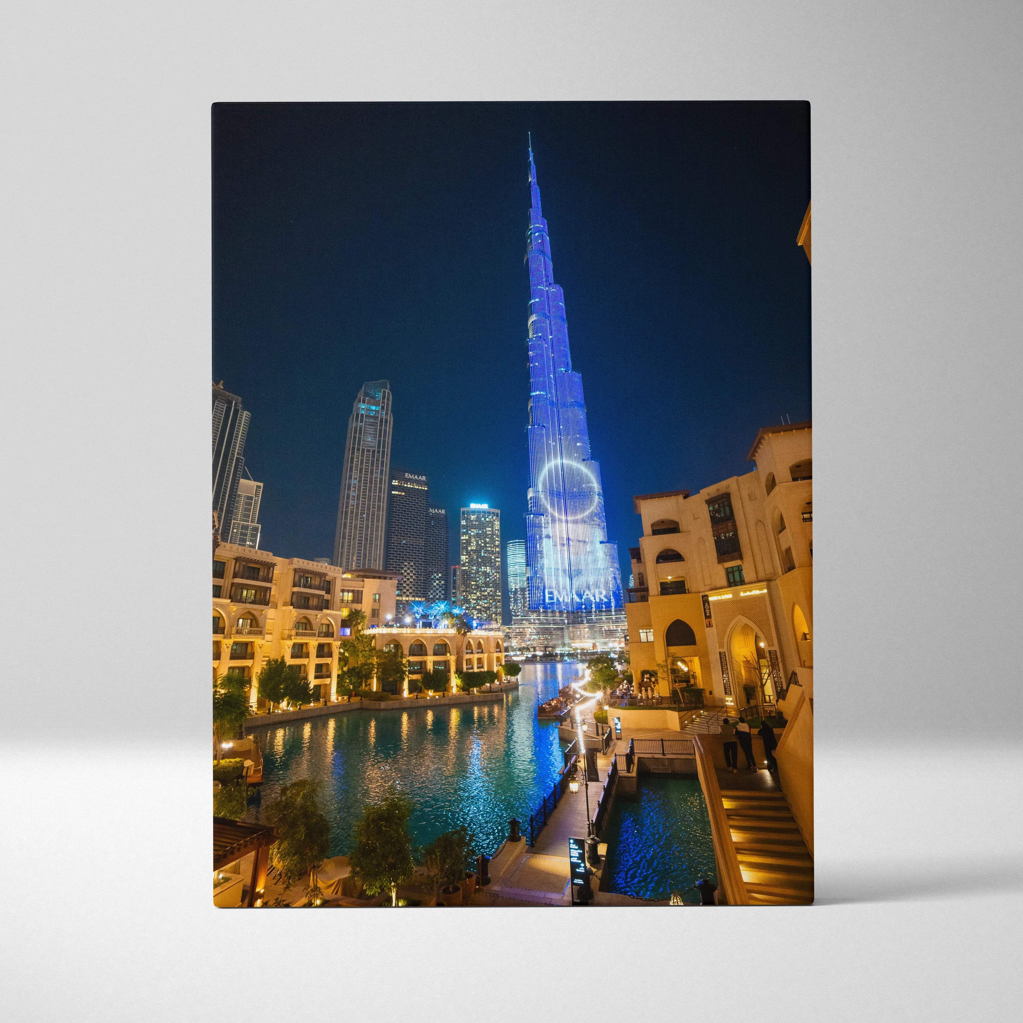 A vibrant canvas print of burj khalifa illuminated in blue neon light with glowing dubai skyline reflections at night