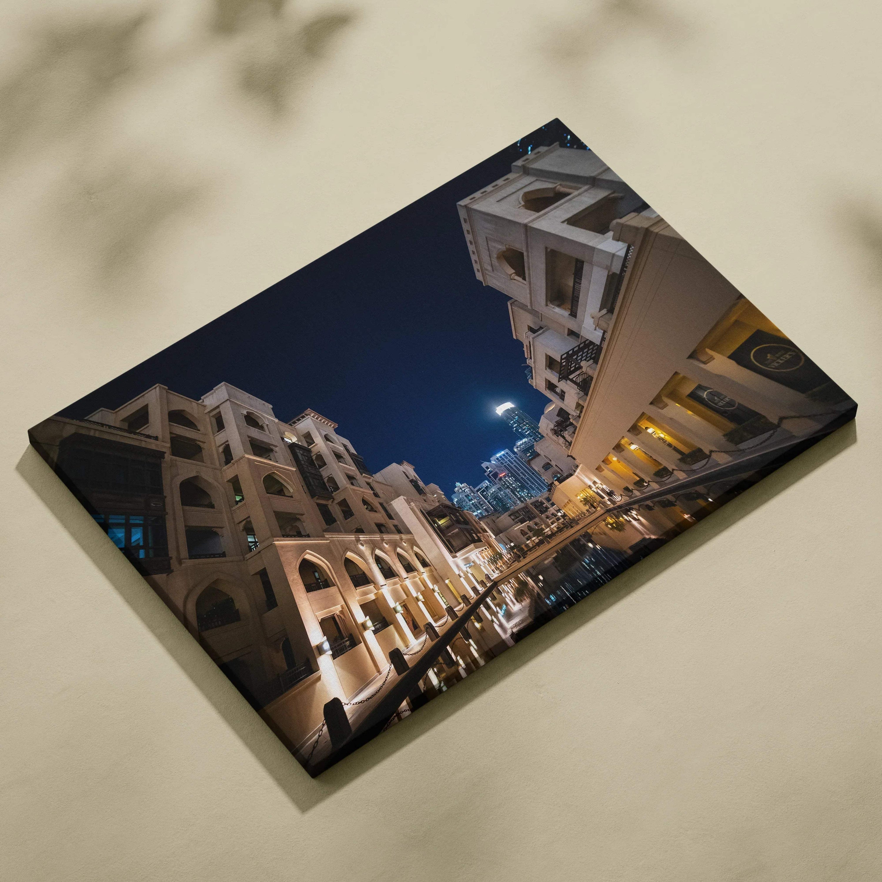 Canvas wall art featuring modern architecture with illuminated beige buildings against a dark blue night sky.