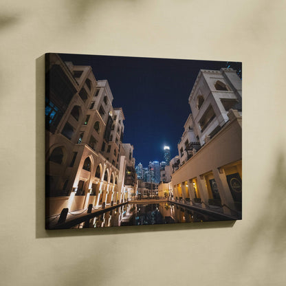 Modern architecture canvas wall art print featuring illuminated buildings at night with reflections on water.