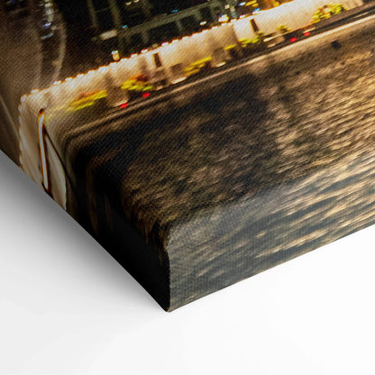 Close-up of wrapped canvas wall art featuring illuminated architectural buildings reflected on water at night.
