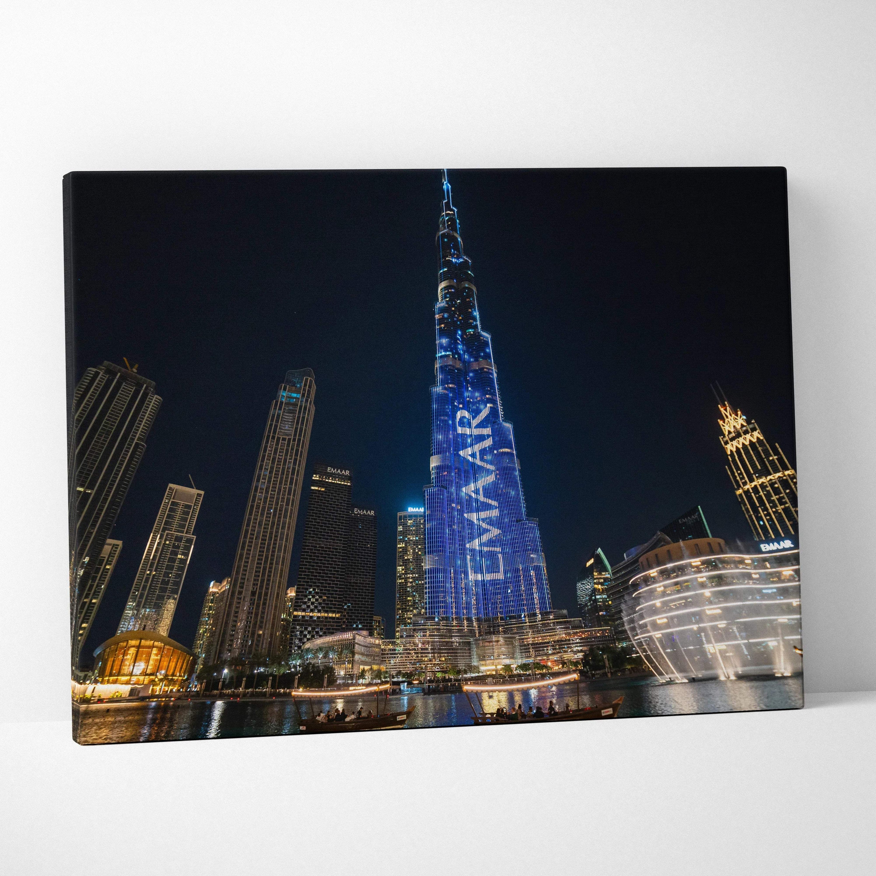 Canvas wall art featuring illuminated modern skyscrapers at night, including a tall building with blue digital signage.