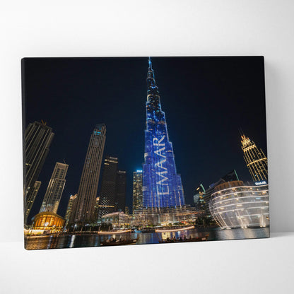 Canvas wall art featuring illuminated modern skyscrapers at night, including a tall building with blue digital signage.