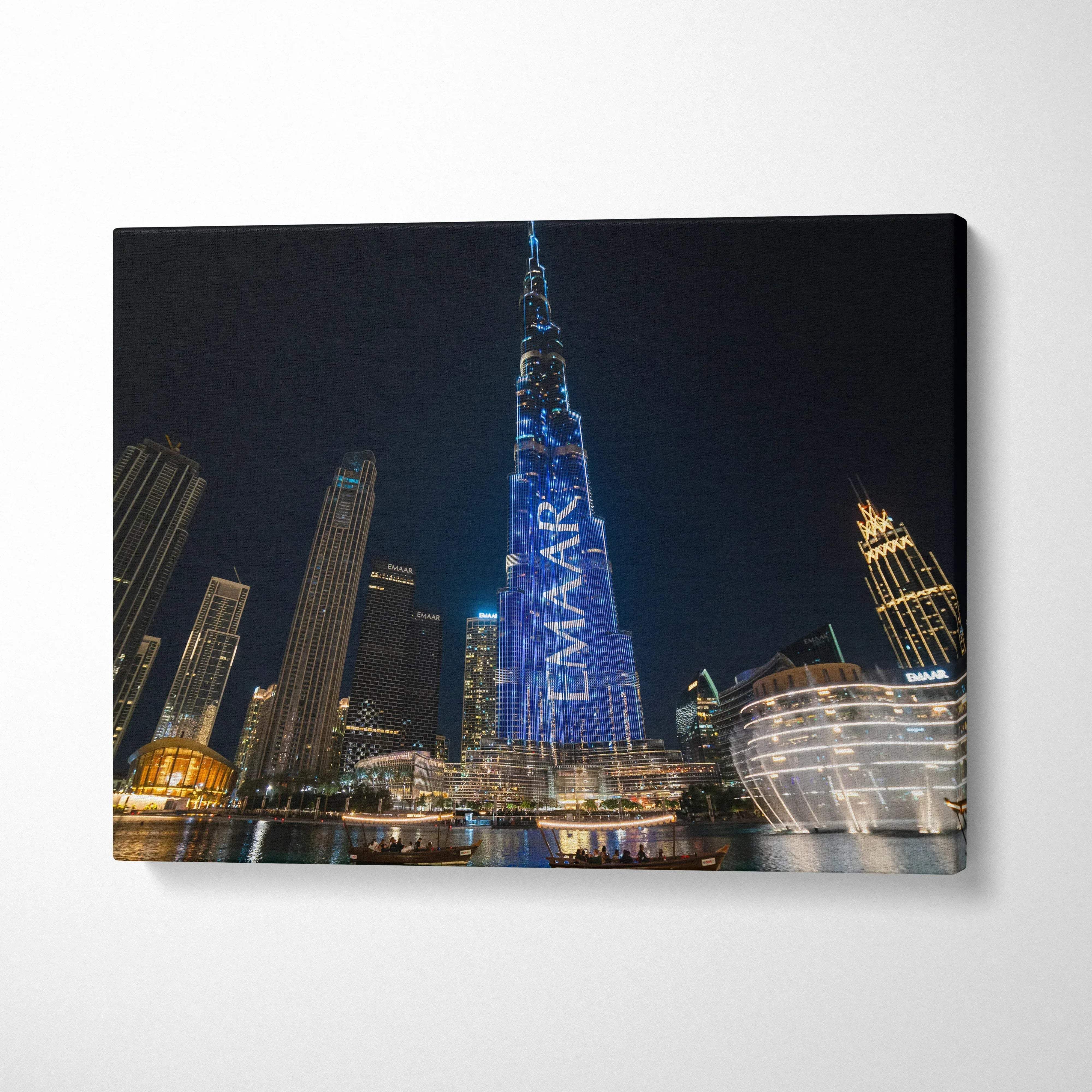 Nighttime city skyline canvas wall art featuring illuminated skyscrapers with a prominent tower displaying "EMAAR" in blue.