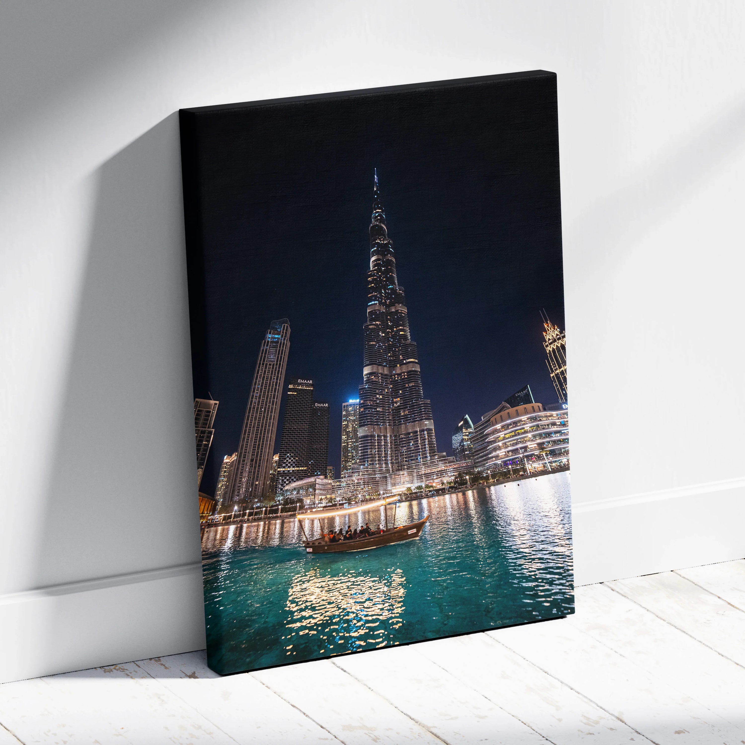 High-resolution canvas wall art of illuminated modern skyscrapers and a boat on water at night.