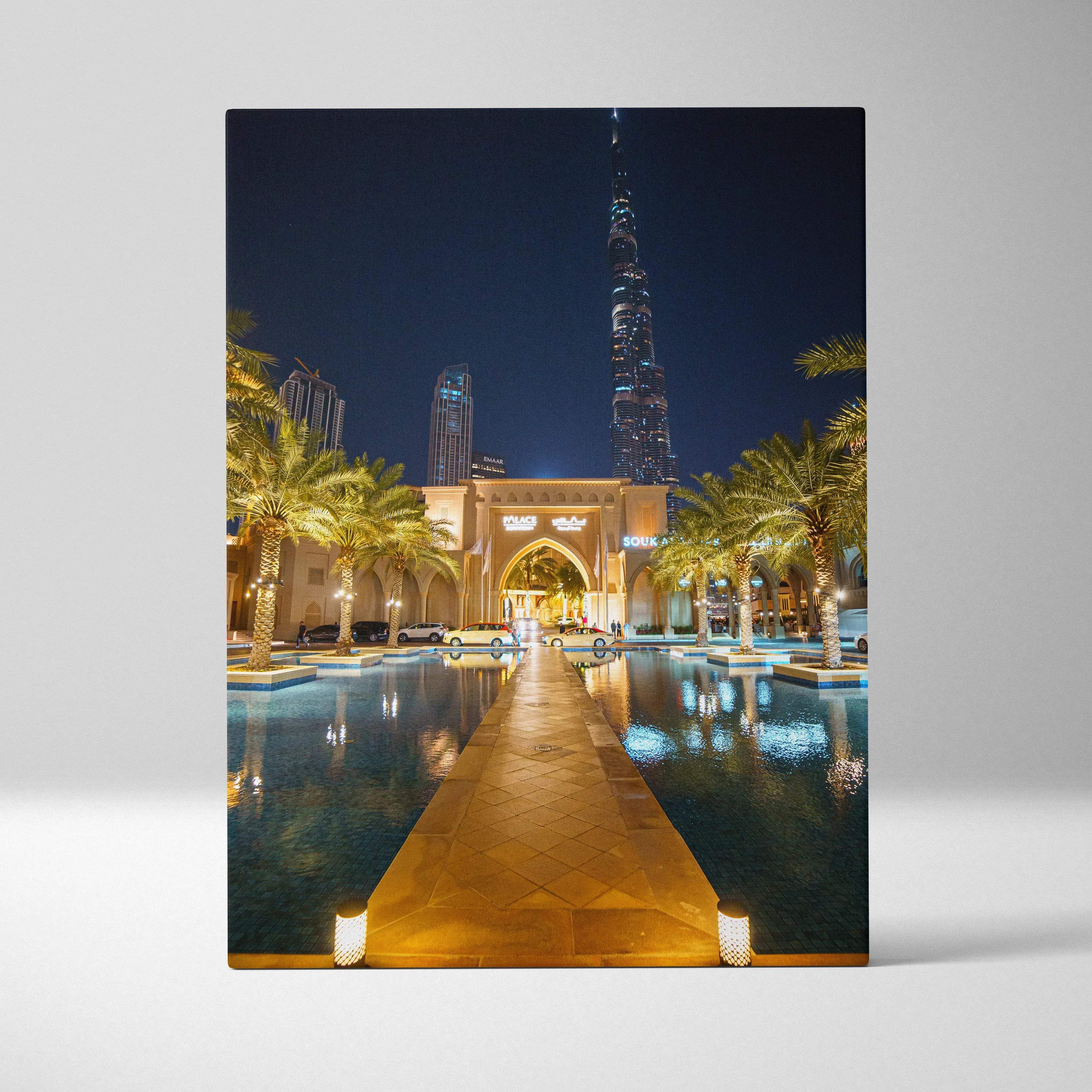 Nighttime canvas print of illuminated burj khalifa and palm-lined walkway with reflective water in warm golden glow