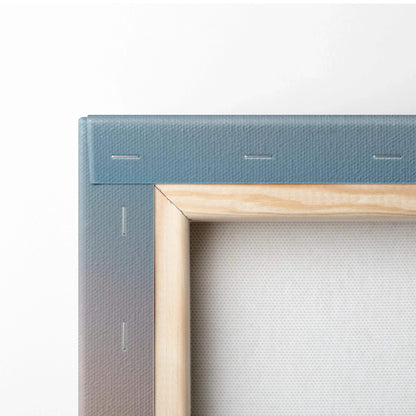 Close-up of beige wooden frame and blue fabric-wrapped canvas corner with visible staples on back of wall art.