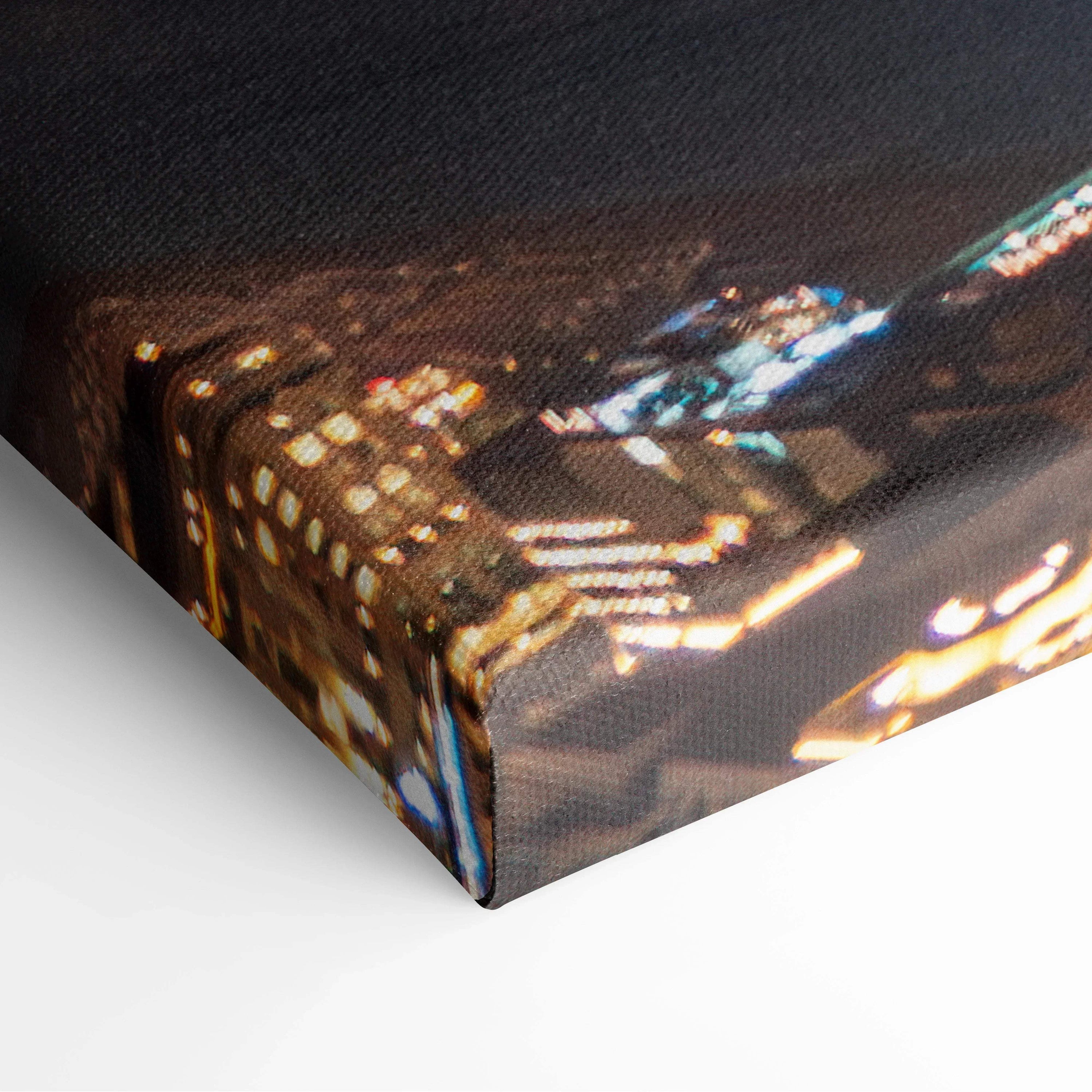 Close-up of edge of canvas wall art with abstract cityscape design in warm tones and illuminated buildings.
