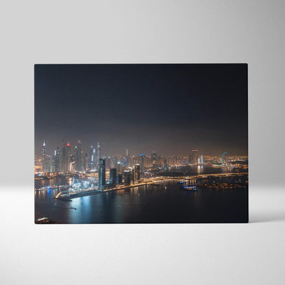 Canvas wall art print featuring a nighttime city skyline with illuminated modern buildings and reflective water.