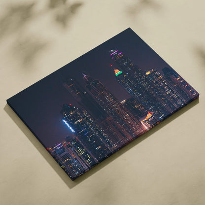 Nighttime cityscape canvas art featuring illuminated skyscrapers with colorful lights on dark blue background.