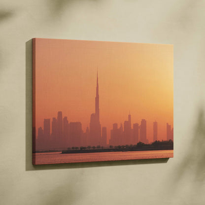 Canvas wall art featuring a warm-toned city skyline with a tall, pointed skyscraper at sunset.
