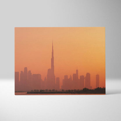 Canvas wall art featuring a warm orange-toned city skyline with tall buildings at sunset.