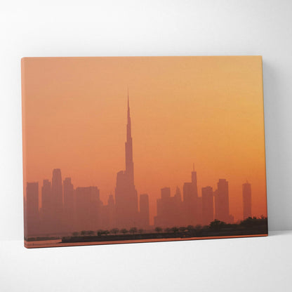 Canvas wall art print featuring a city skyline silhouette at sunset with warm orange tones.