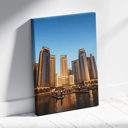 Vertical canvas wall art featuring modern city skyscrapers with a clear blue sky background.