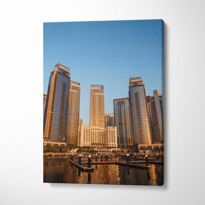Canvas wall art featuring modern skyscrapers at sunset with reflective water foreground.