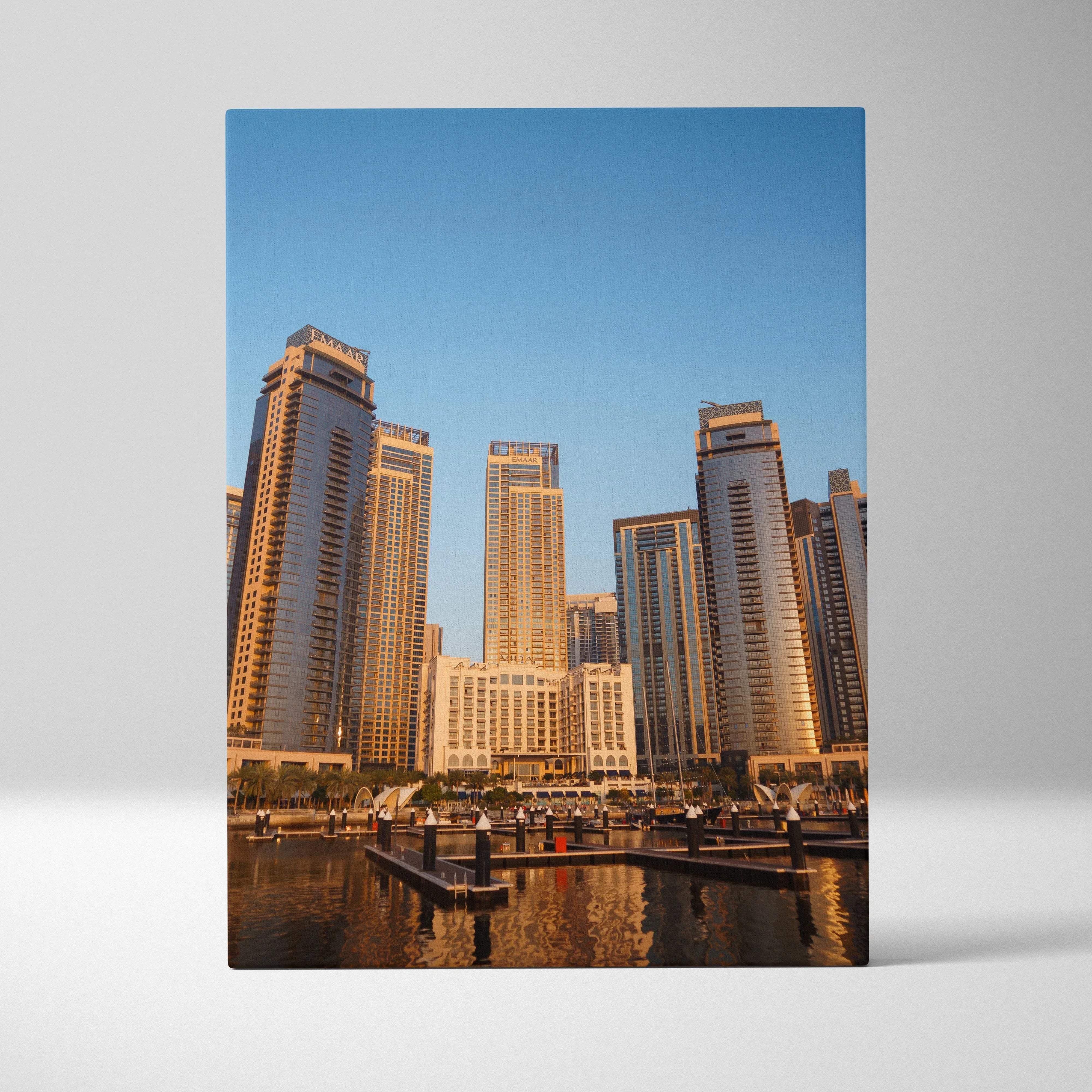 Canvas print of modern urban skyline with glass skyscrapers reflecting warm golden hour sunlight against blue sky