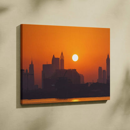 Sunset city skyline canvas wall art with warm orange tones and silhouetted buildings.