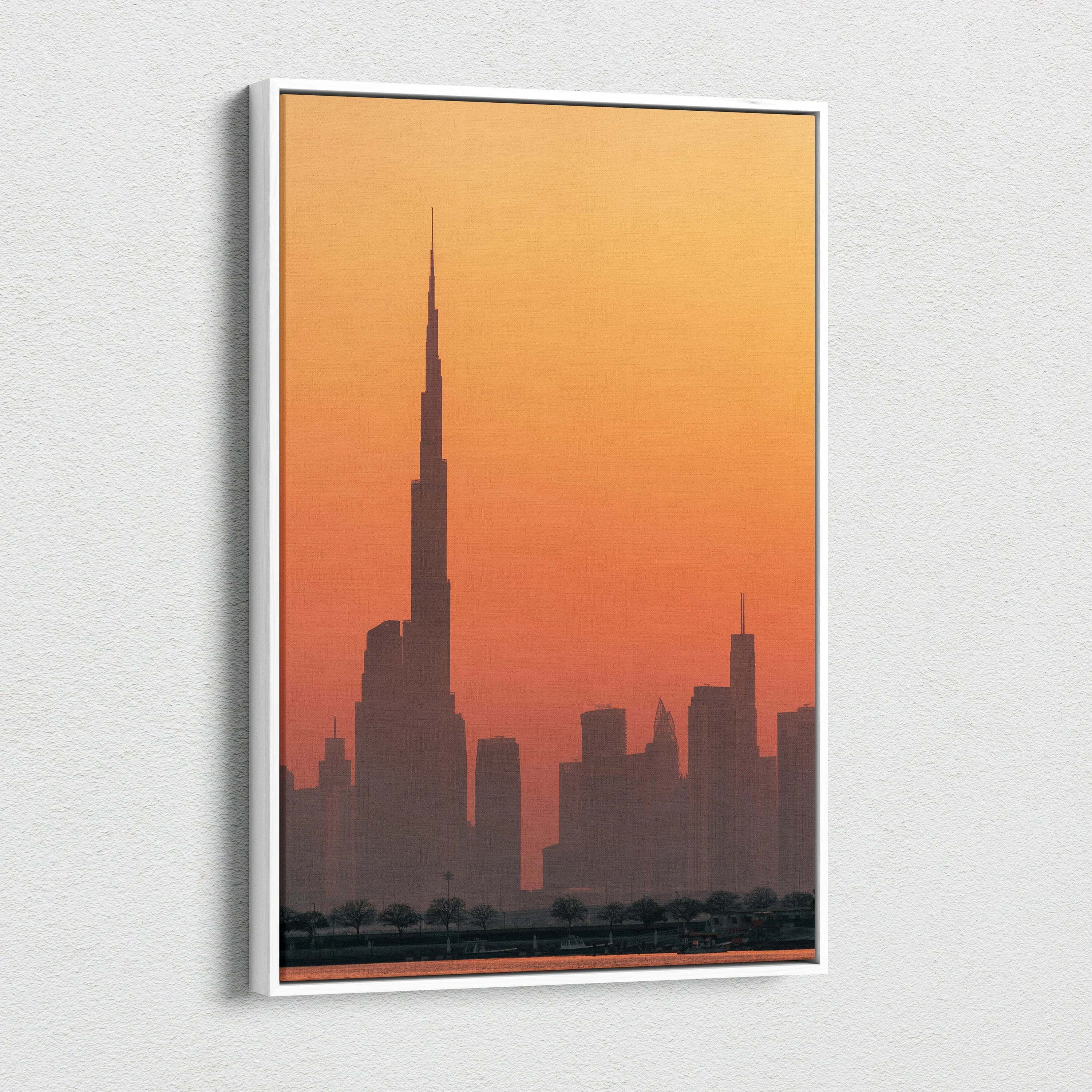 Tall skyscraper silhouette against a warm orange sunset on a vertical canvas wall art.