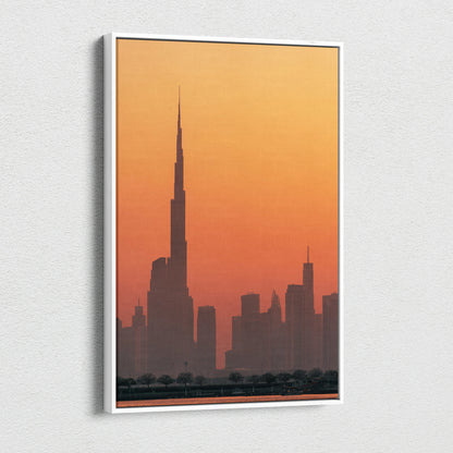 Tall skyscraper silhouette against a warm orange sunset on a vertical canvas wall art.