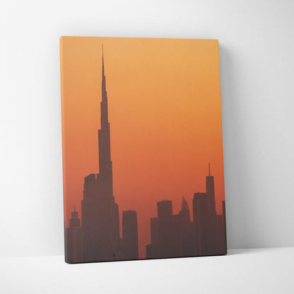 Canvas wall art featuring a silhouette of a city skyline against an orange gradient sky.