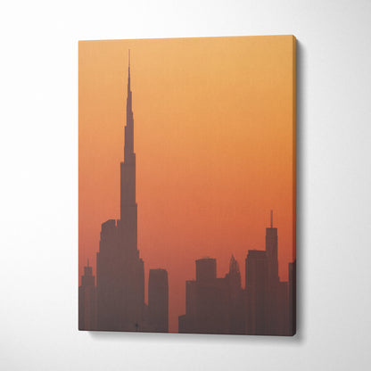 Canvas wall art featuring a silhouette of a city skyline at sunset with orange and red tones.