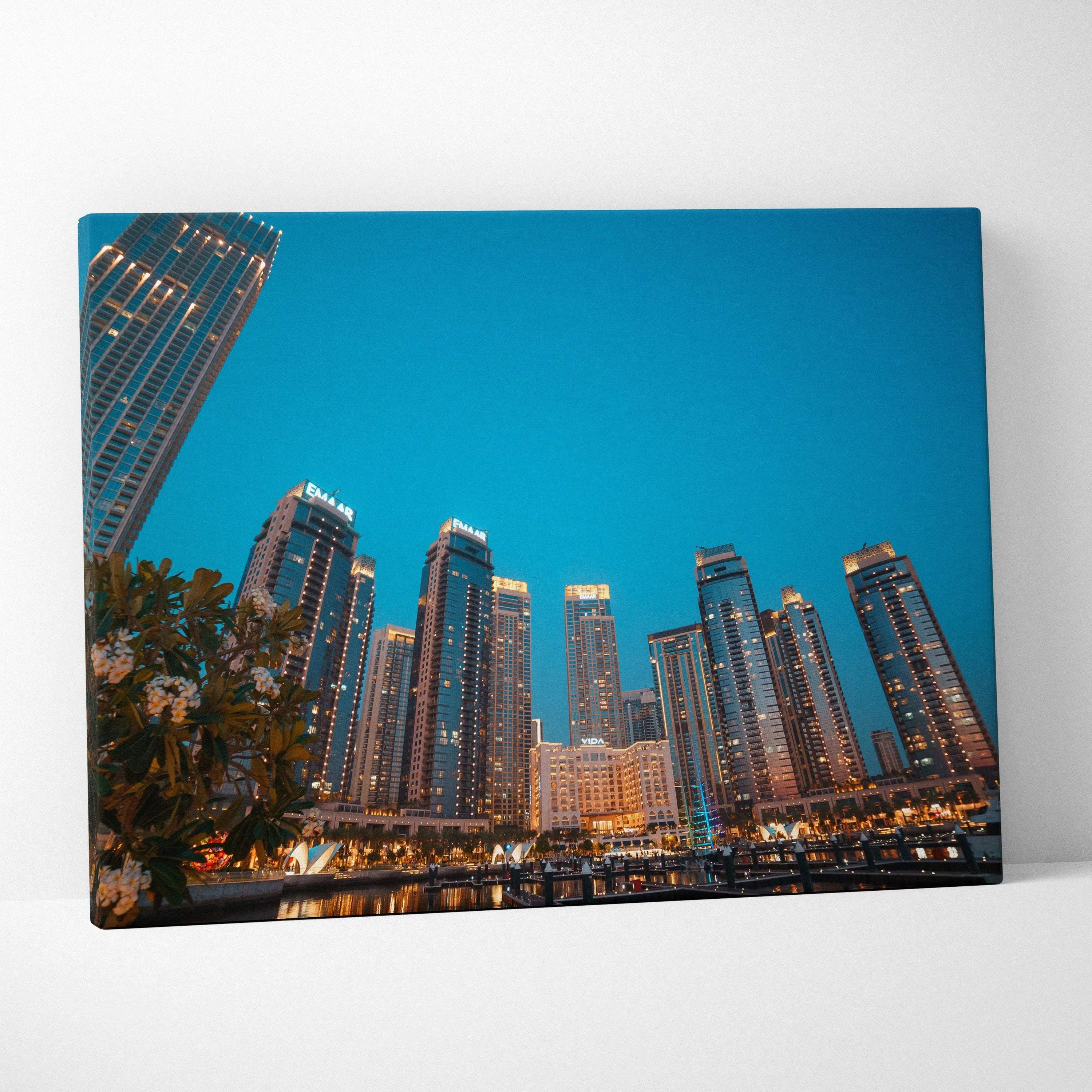 Canvas wall art print featuring illuminated modern skyscrapers against a deep blue evening sky.