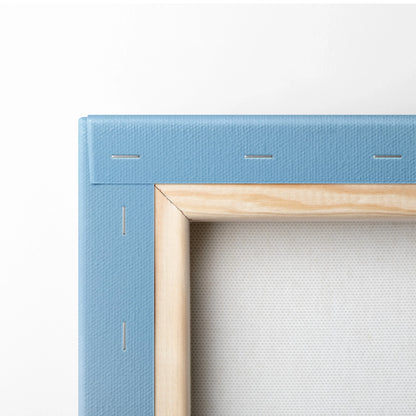 Close-up of blue-stretched canvas with wooden frame corner and visible staples on the back of wall art canvas.