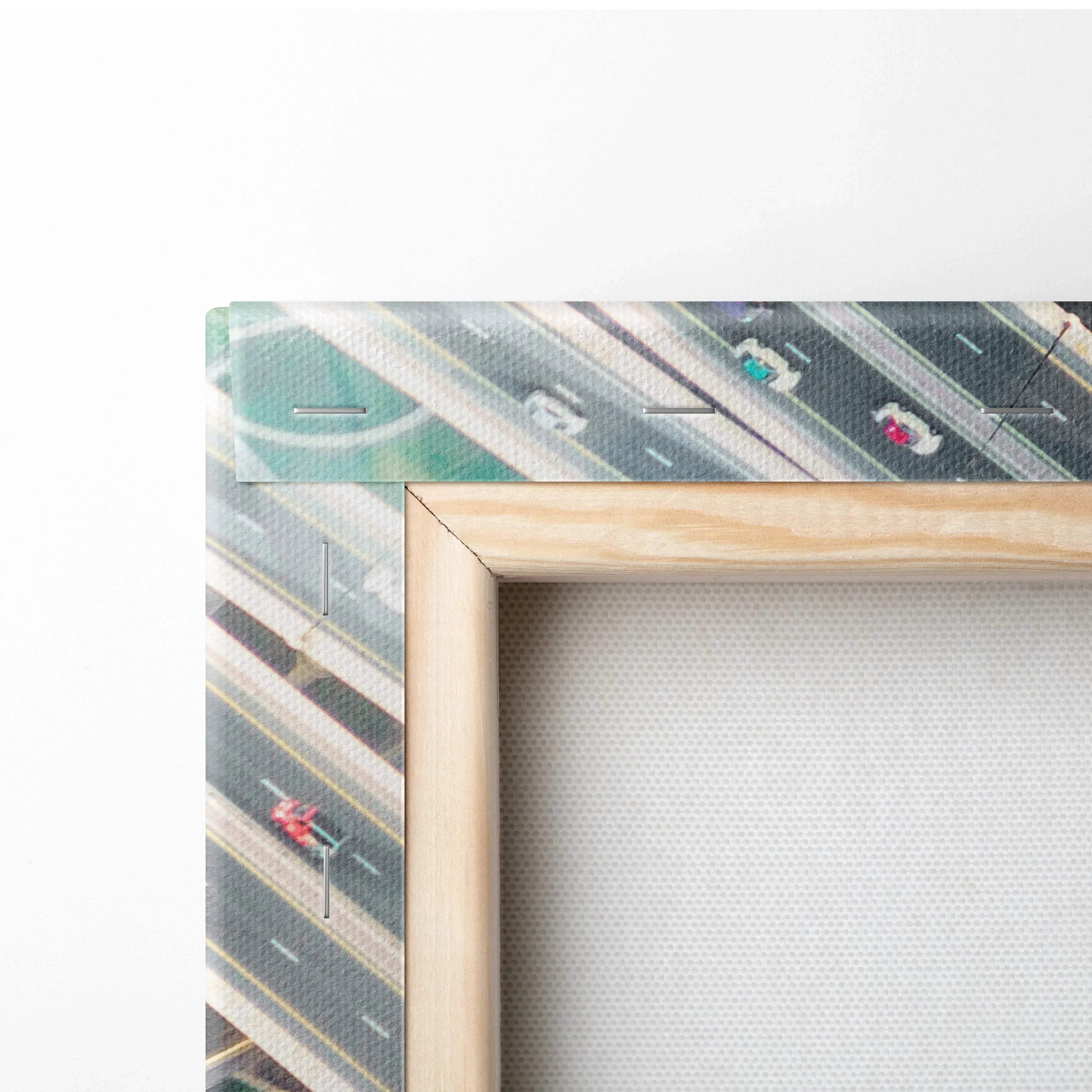 Close-up of corner showing beige wooden frame with stretched textured canvas and printed abstract architectural design in.