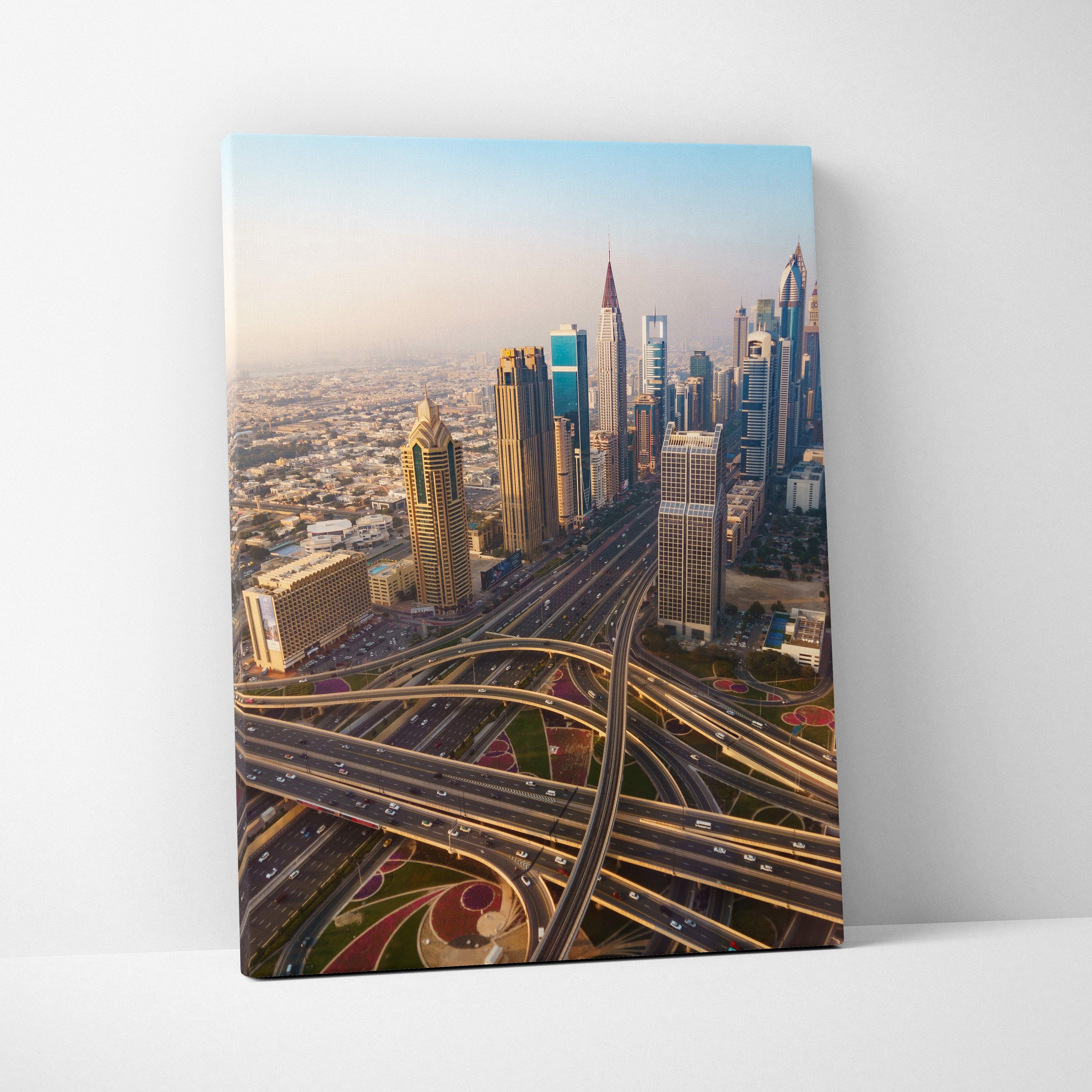 Canvas wall art featuring a colorful aerial view of modern skyscrapers and intricate highway interchanges at sunset.