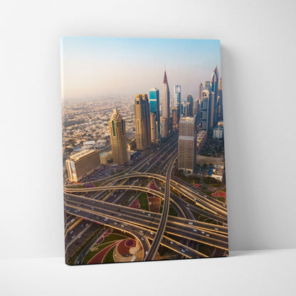 Canvas wall art featuring a colorful aerial view of modern skyscrapers and intricate highway interchanges at sunset.