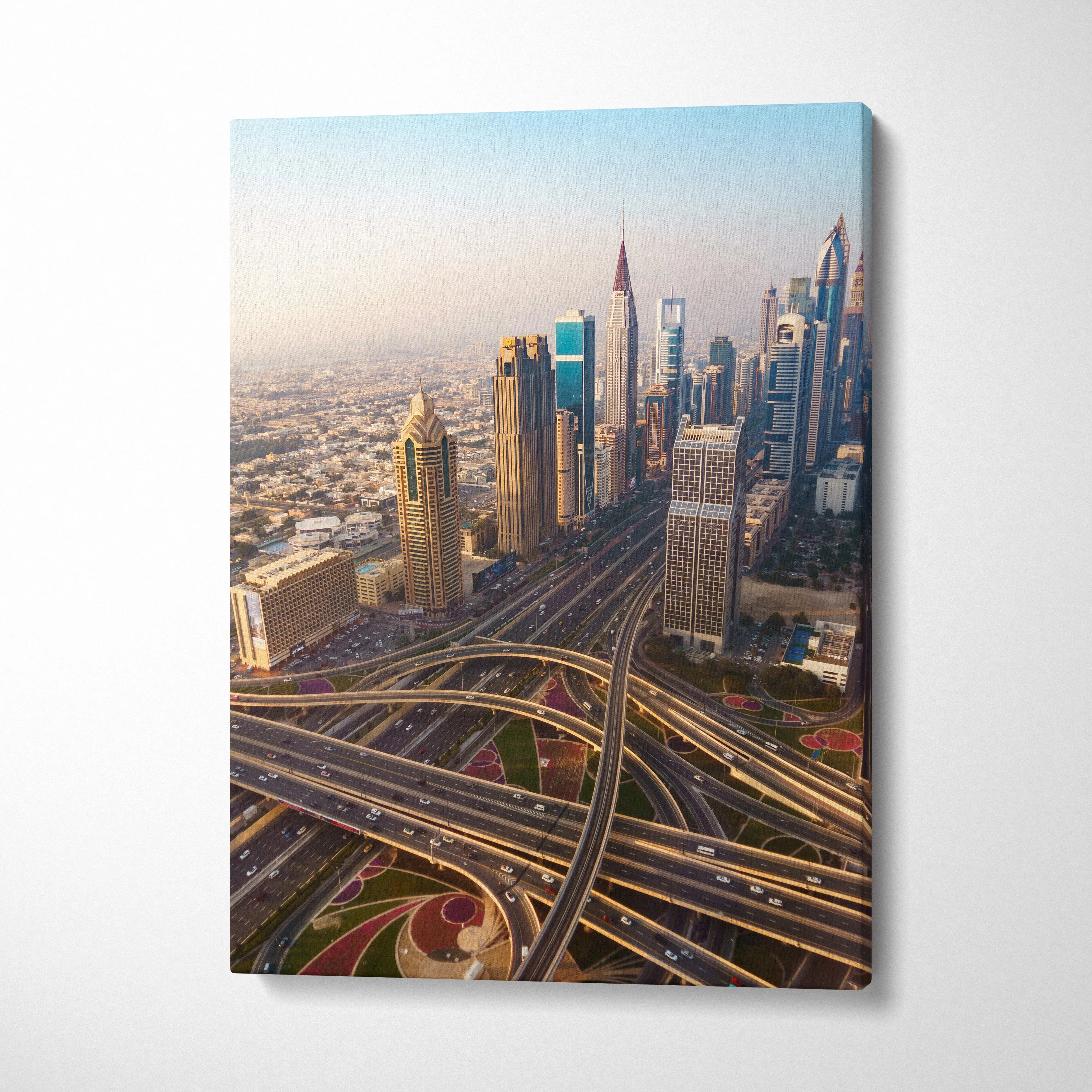 Vertical canvas wall art of a vibrant city skyline with modern skyscrapers and intricate highway interchanges at sunset.