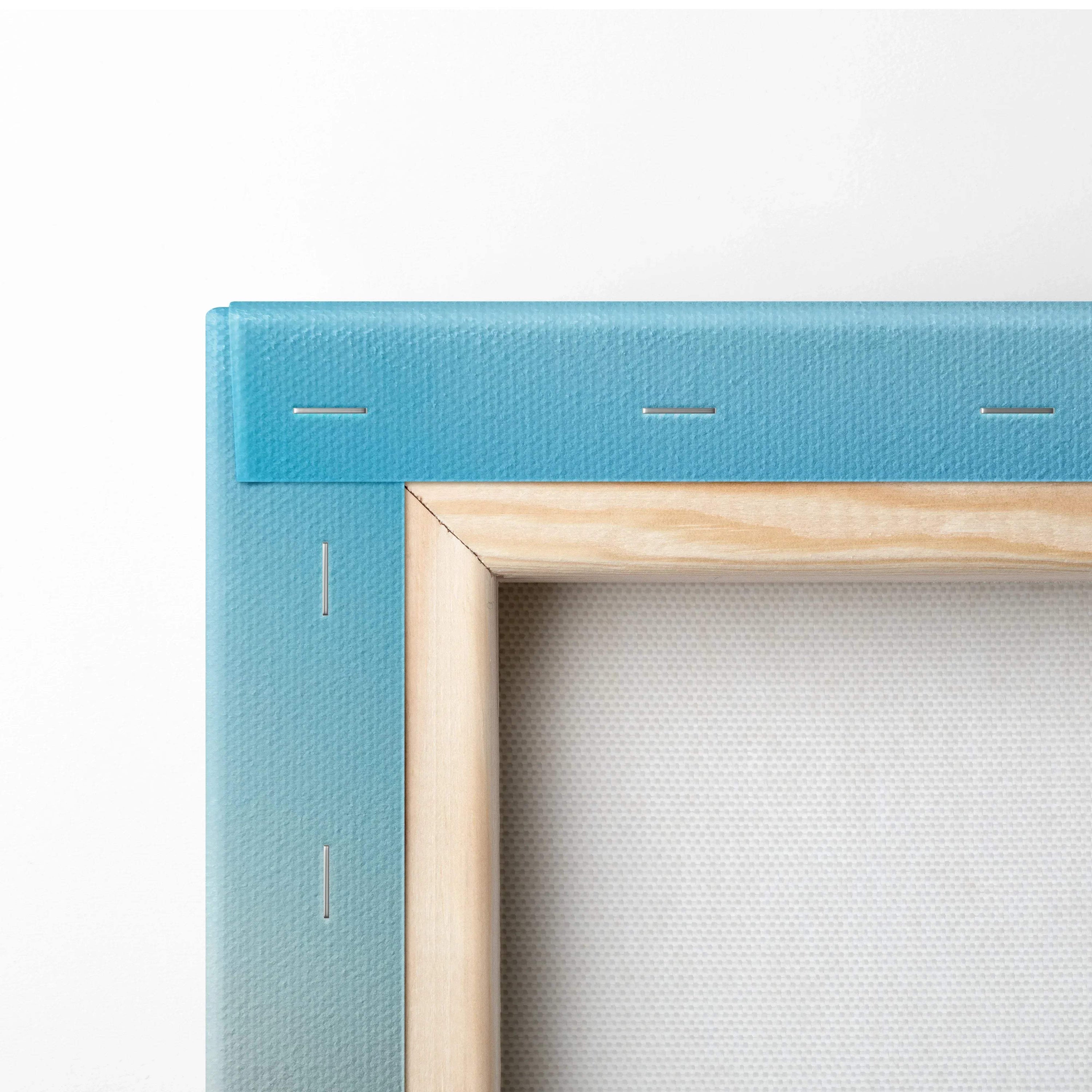 Close-up of stretched canvas with gradient blue edge and natural wooden frame for wall art display.