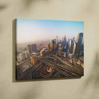 Canvas wall art featuring an aerial view of a modern cityscape with intricate highways and skyscrapers under a clear blue.