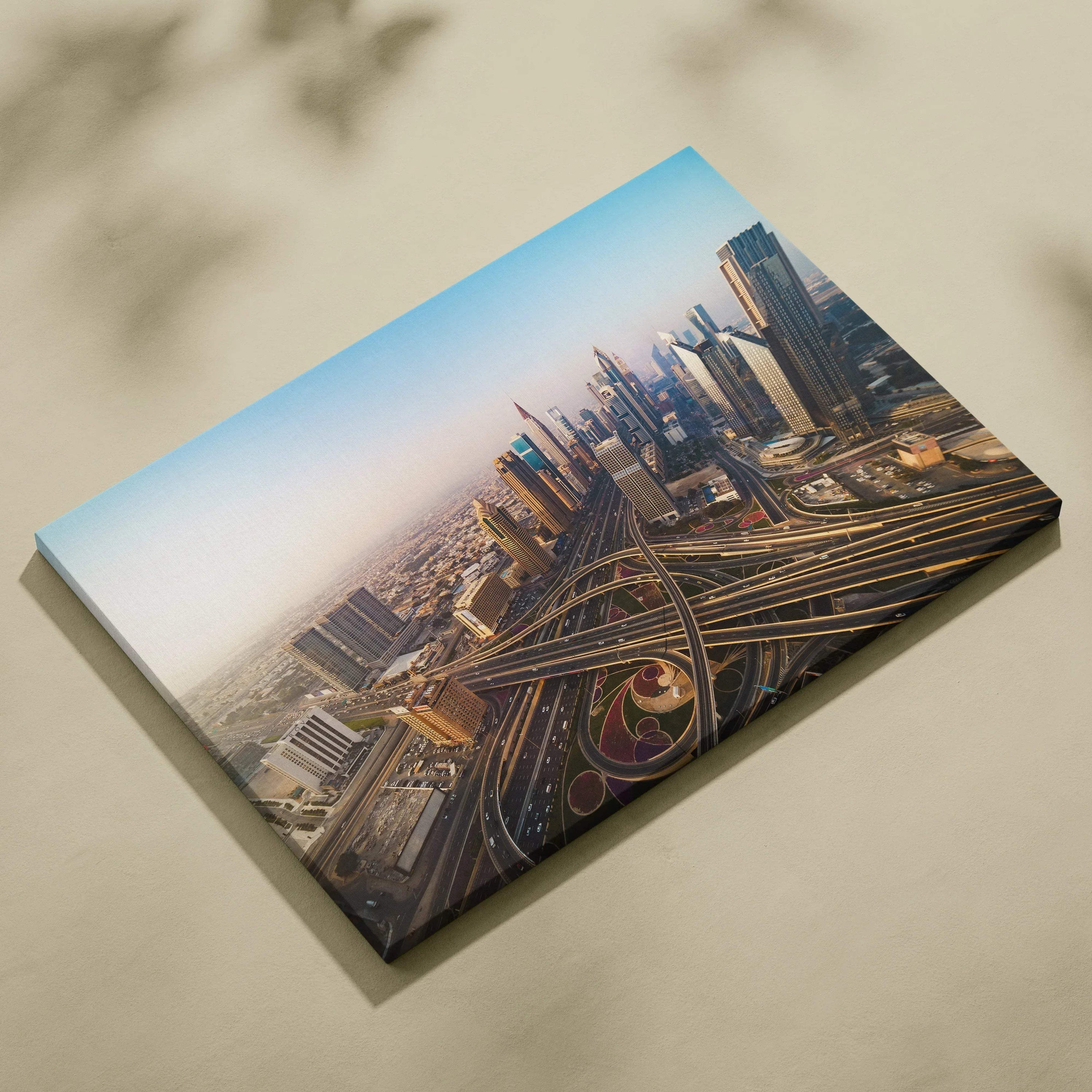 Canvas wall art featuring an aerial view of a cityscape with modern skyscrapers and intricate highway interchanges under a.