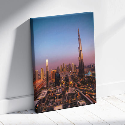Vertical canvas wall art featuring a dusk cityscape with illuminated skyscrapers and the Burj Khalifa towering in the.