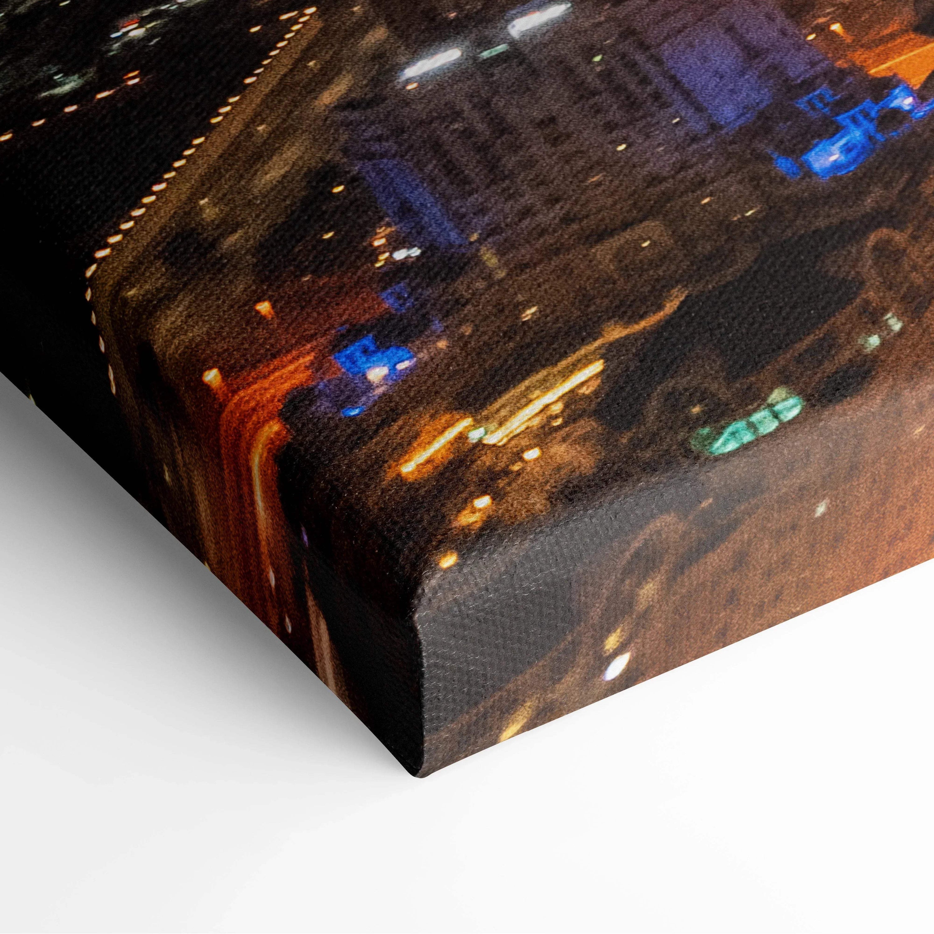 Corner view of premium canvas wall art print featuring illuminated urban architecture at night in warm and cool tones.