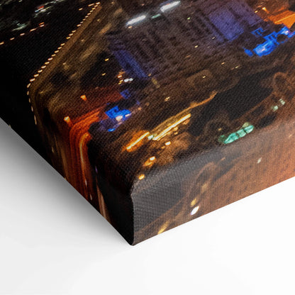 Corner view of premium canvas wall art print featuring illuminated urban architecture at night in warm and cool tones.