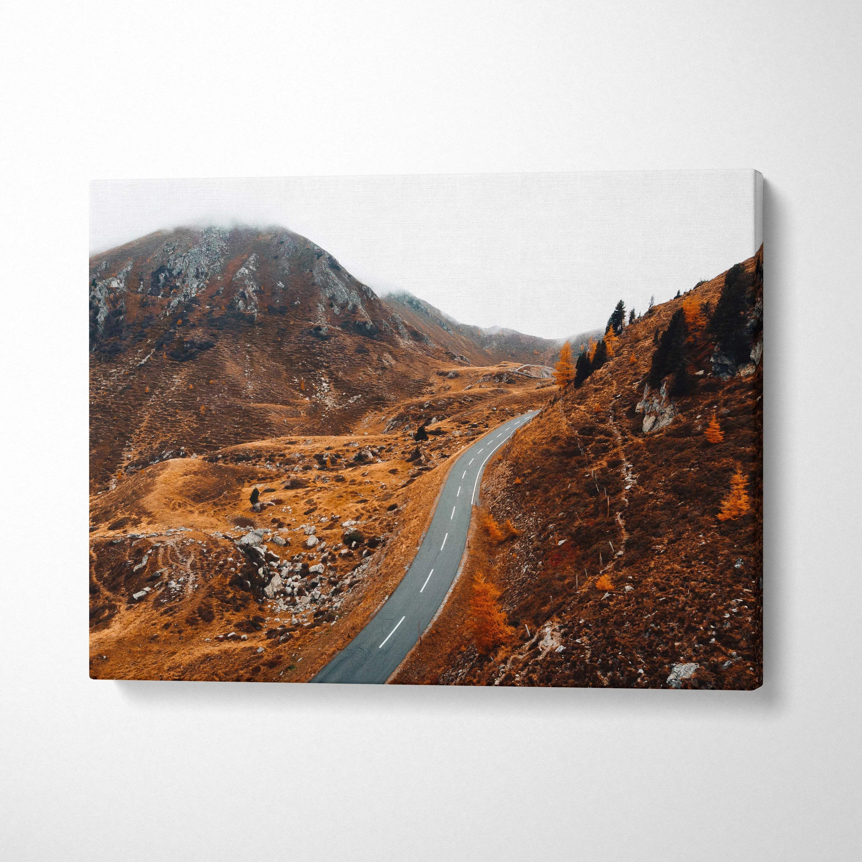 Canvas wall art of a winding road through brown autumn hills under a gray sky.