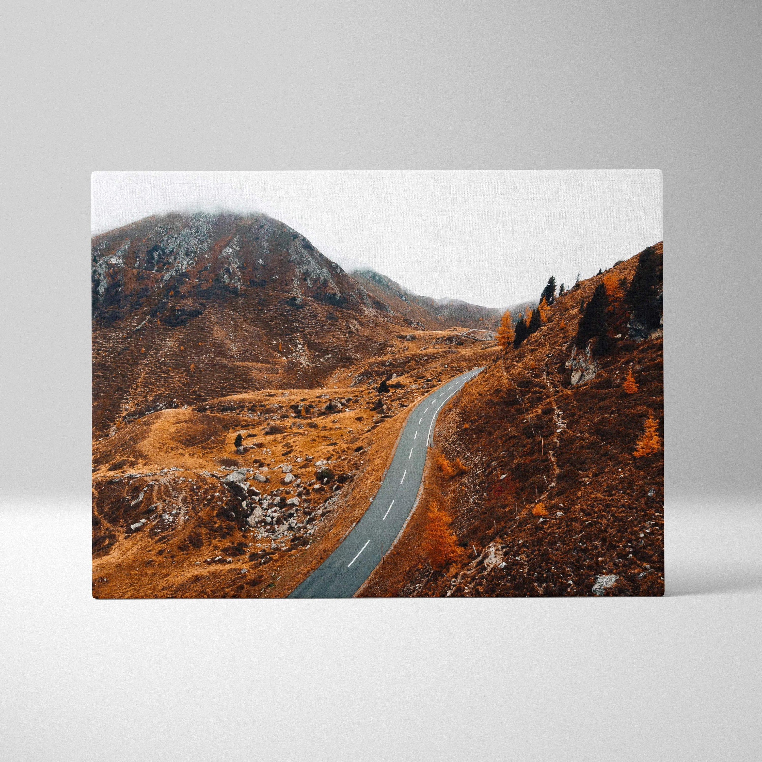 Canvas wall art of a winding road through autumn hills with vibrant fall foliage in warm tones.