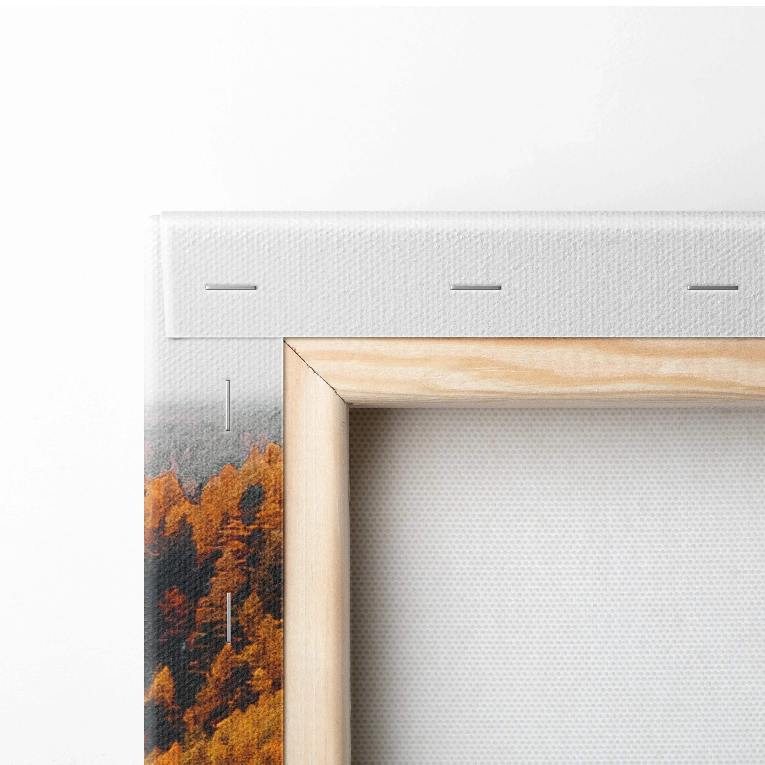 Corner detail of canvas wall art with vibrant autumn trees and wooden frame edge.