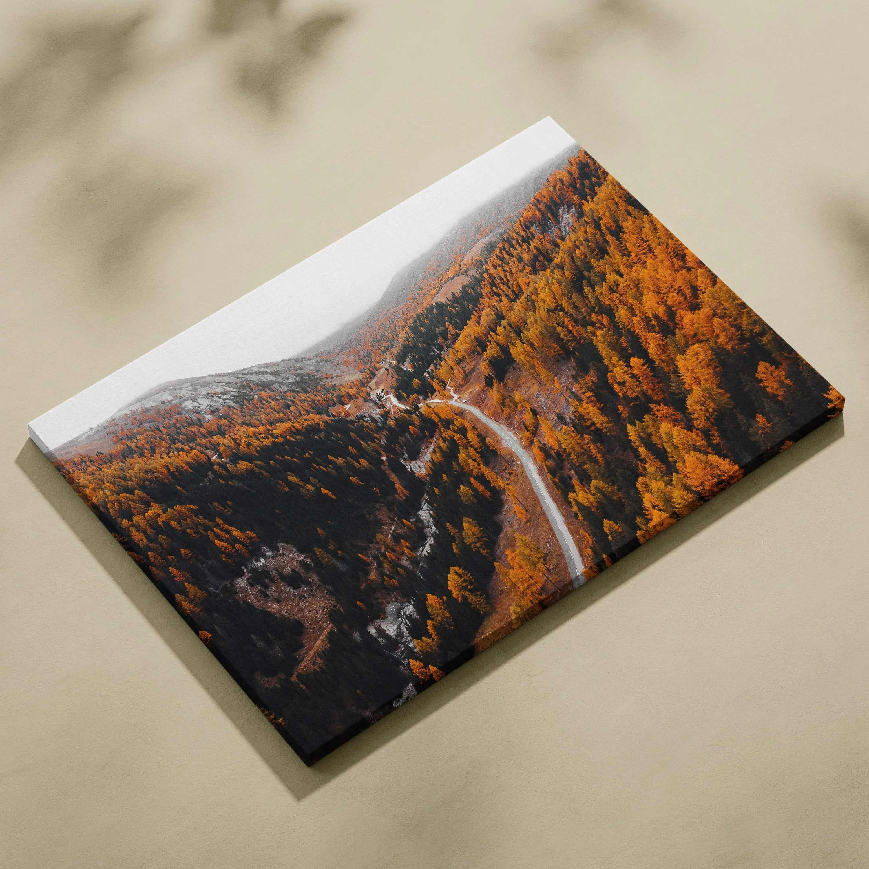 Autumn road winding through vibrant orange and red foliage under clear blue sky on canvas wall art.