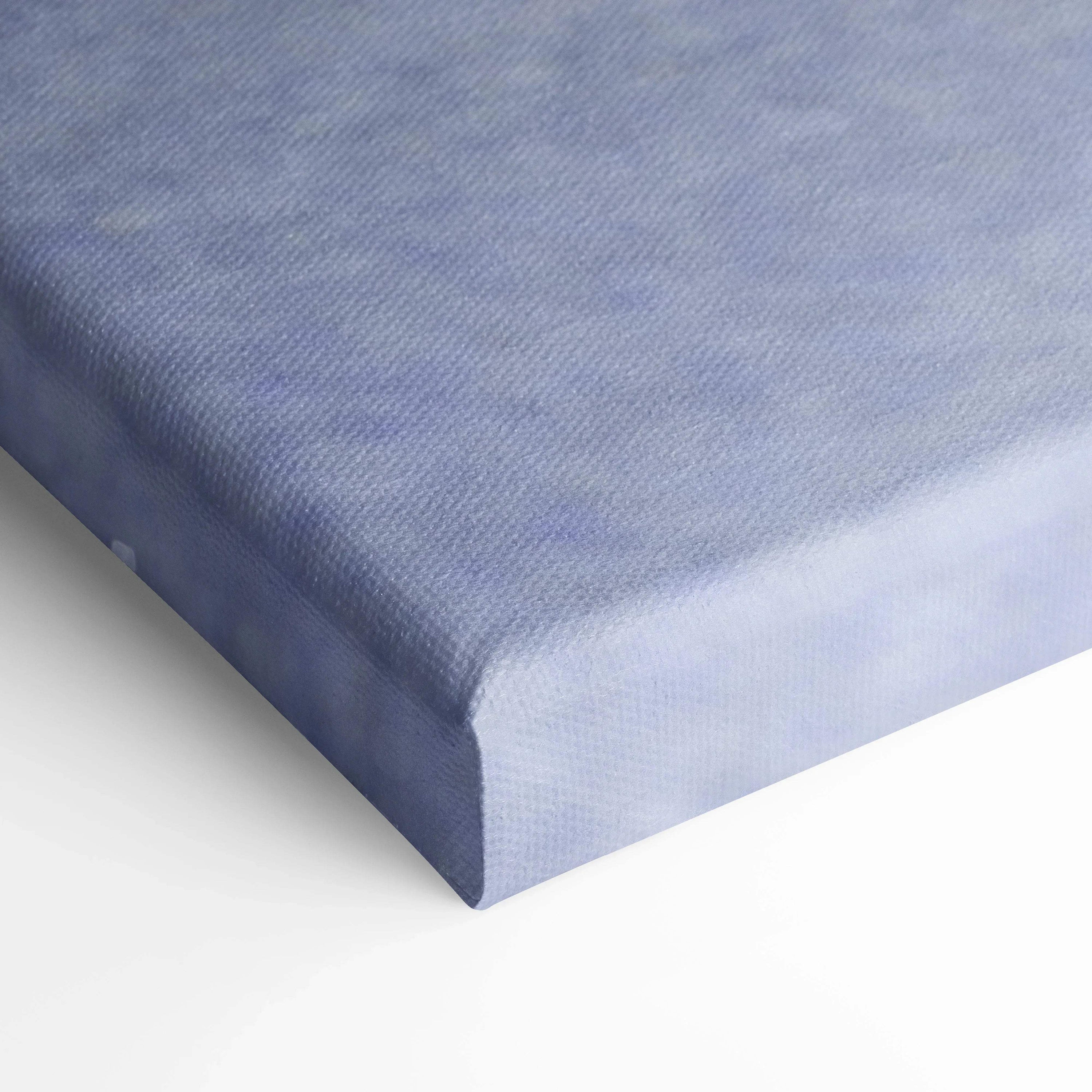 Close-up of blue canvas wall art corner with textured fabric and wrapped edges.