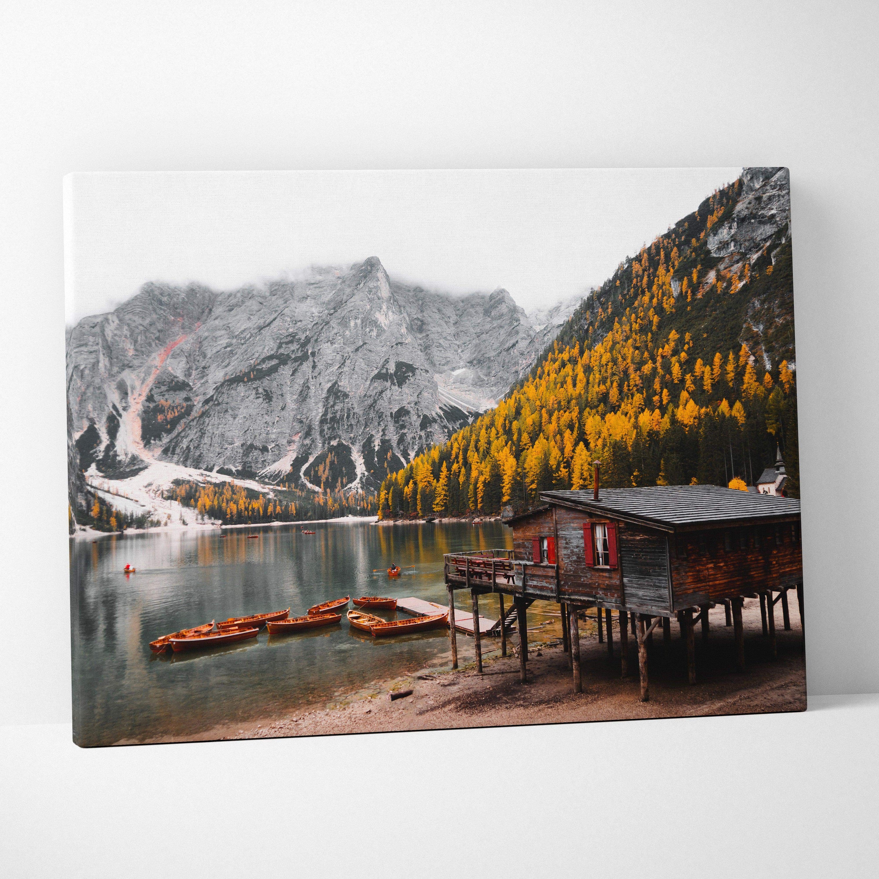 Canvas wall art featuring vibrant autumn foliage with golden leaves and a lakeside cabin at mountain base.