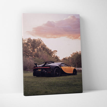 Bugatti Chiron on grass at sunset canvas wall art with purple and orange sky.