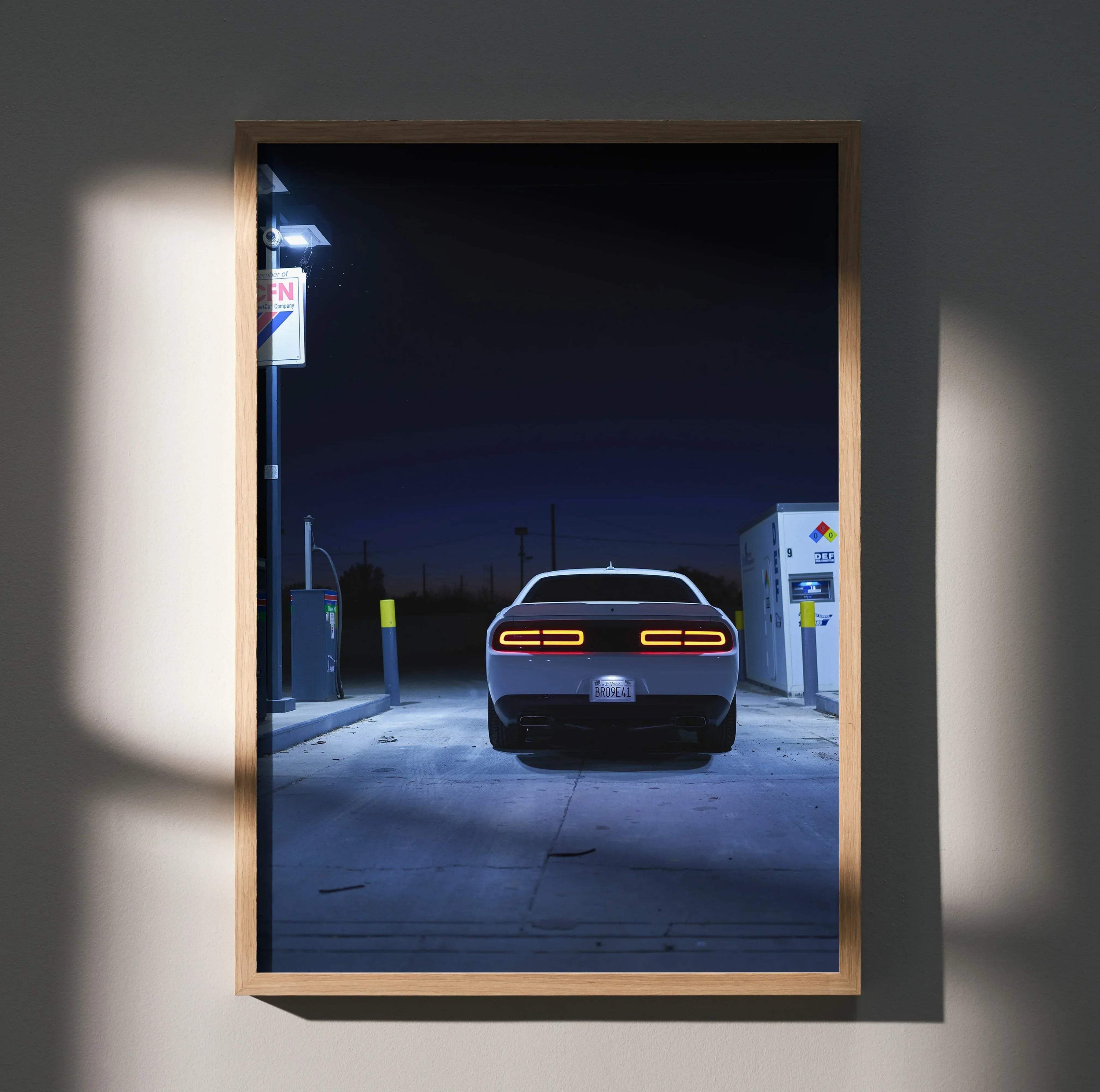 Dodge Challenger rear view at gas station at night poster wall art in wooden frame.