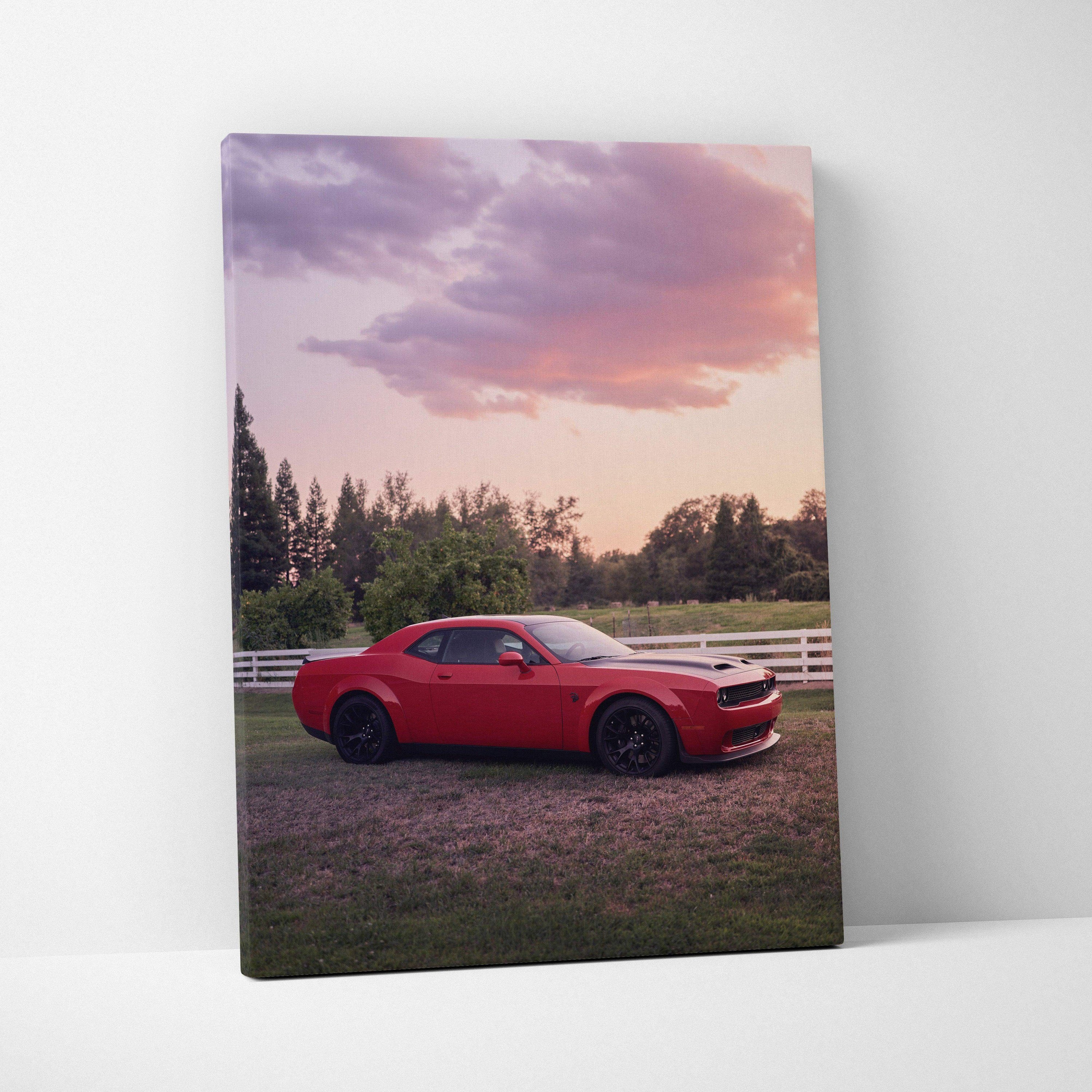 Red Dodge Challenger Hellcat parked near white fence at sunset canvas wall art.