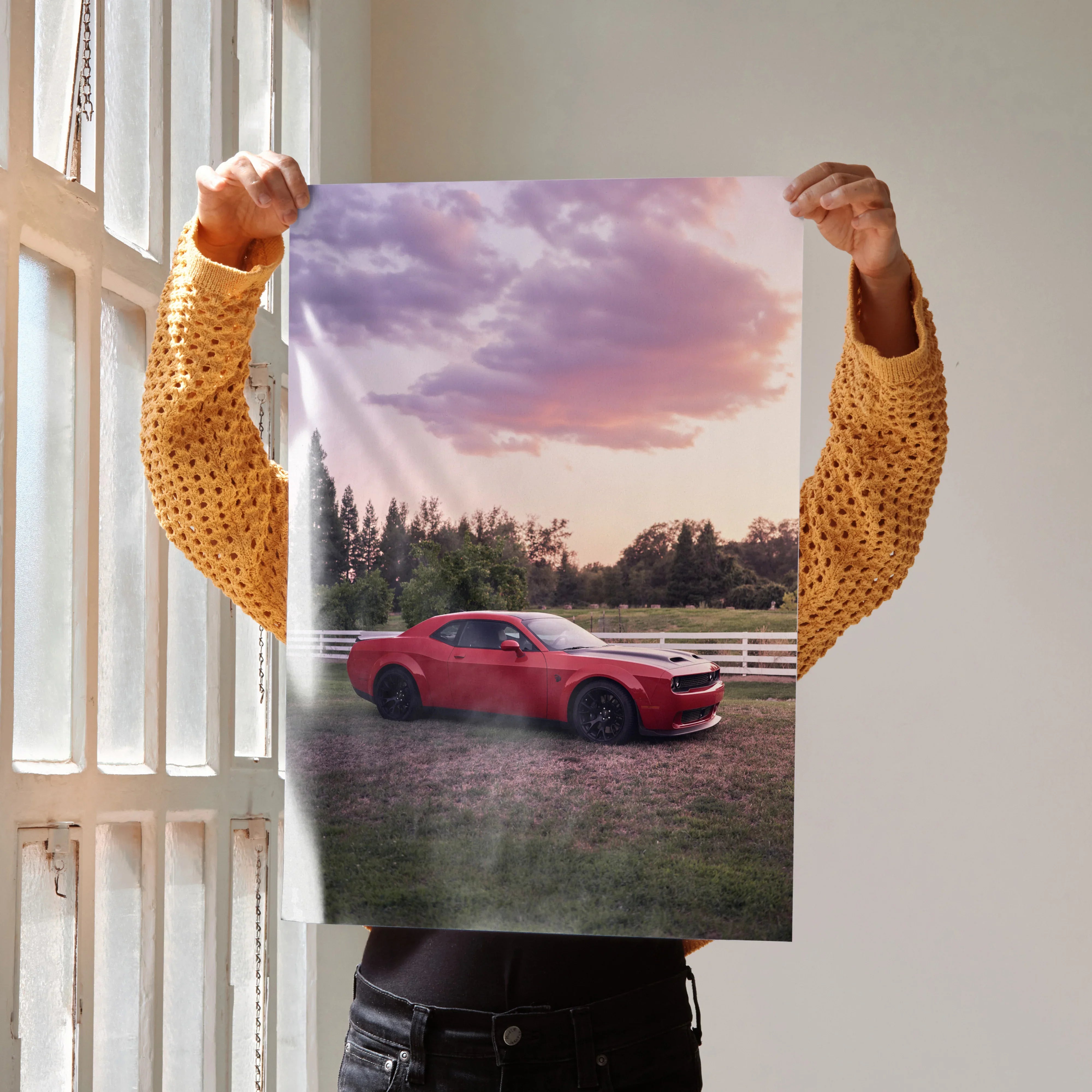 Dodge Challenger Hellcat in red parked on grass at sunset poster wall art.
