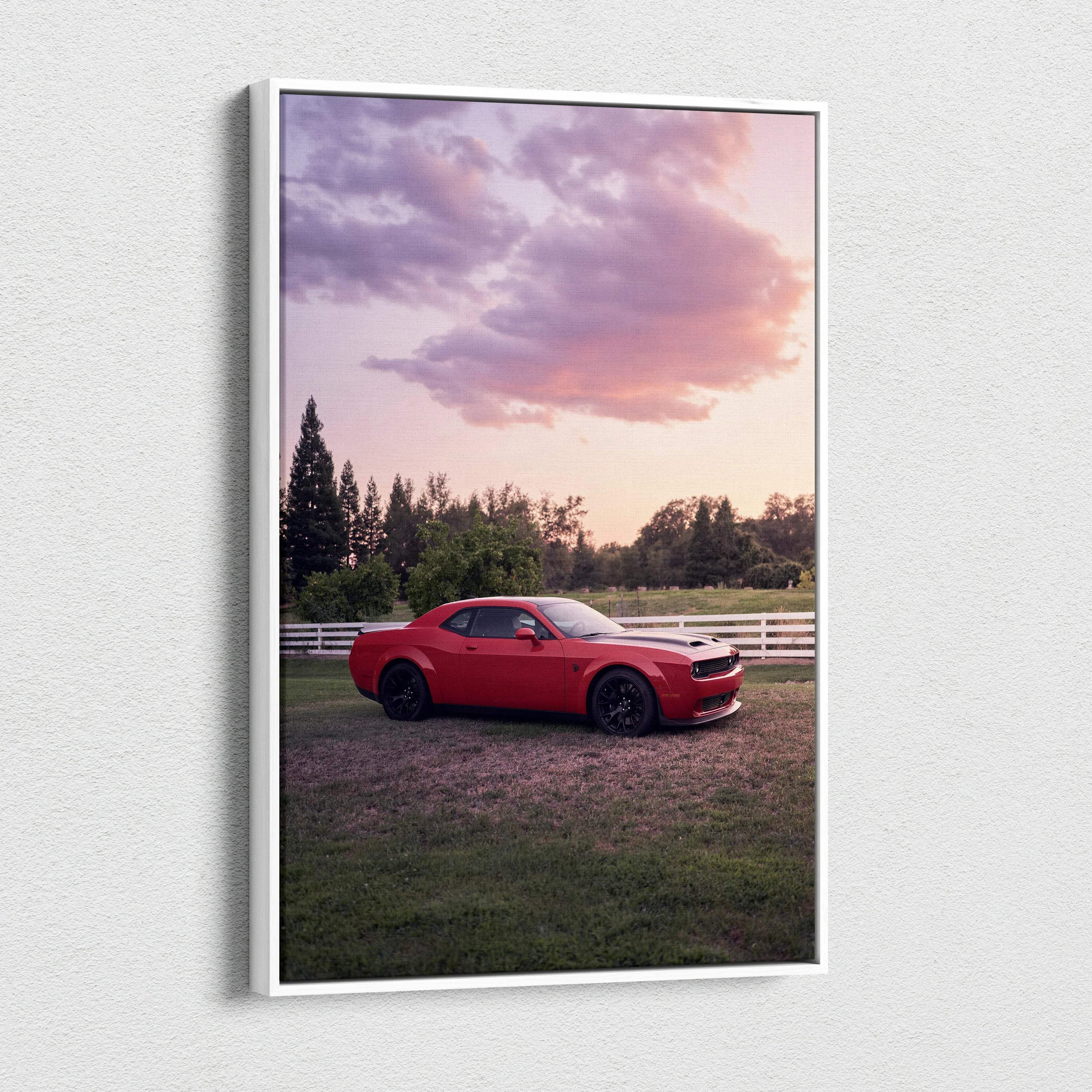 Red Dodge Challenger Hellcat parked in grassy field under purple and pink sunset sky canvas wall art.